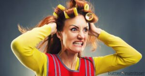 Crazy housewife with curlers isolated on gray